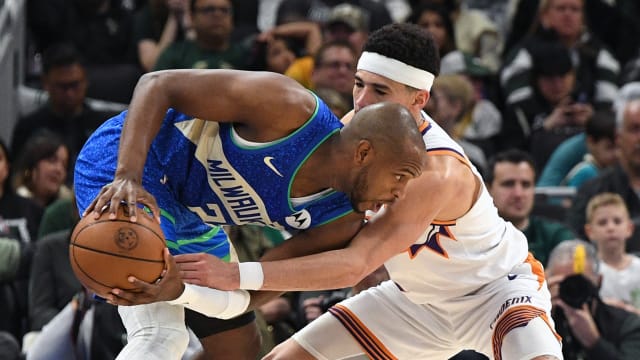 Phoenix Suns guard Devin Booker (1) defends against Milwaukee Bucks forward Khris Middleton (22) 